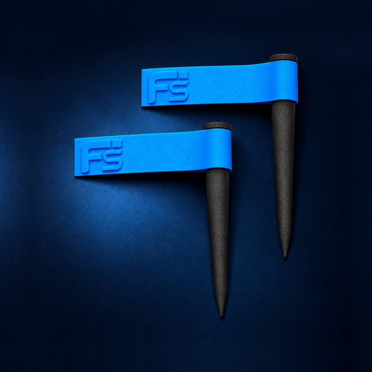 Two FlagSwings on a dark navy background, each a pointed black stake topped by a blue flag with the FlagSwing logo raised on it.